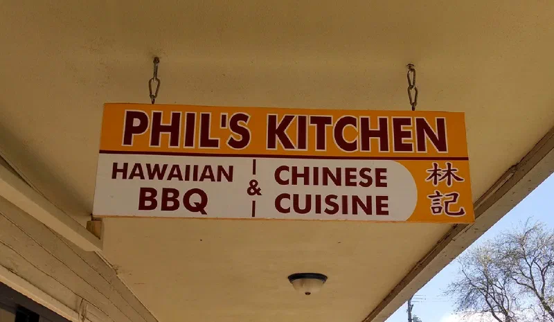 A hanging sign reading “Phil’s Kitchen — Hawaiian BBQ & Chinese Cuisine”.