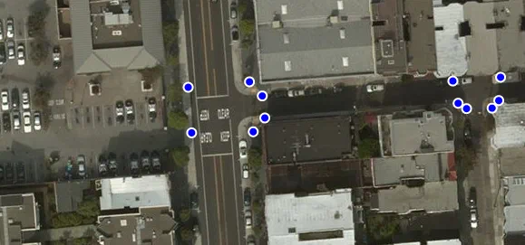 A satellite view of a San Francisco intersection with a blue dot marking each curb ramp.